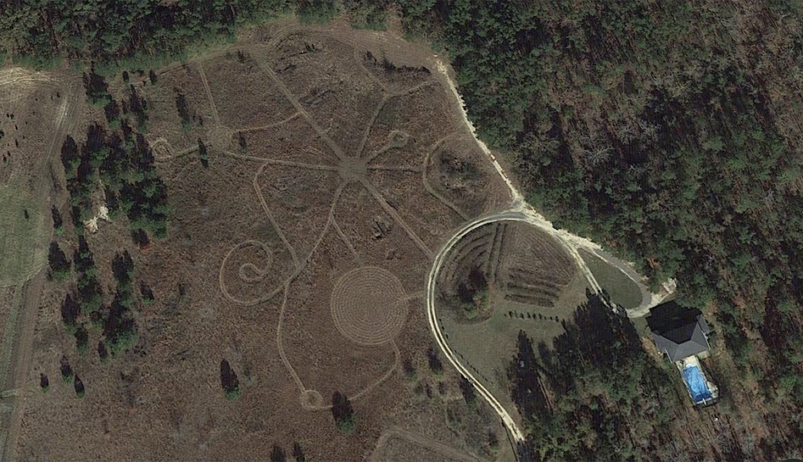 Aerial view of a large crop circle garden with circular patterns and winding pathways