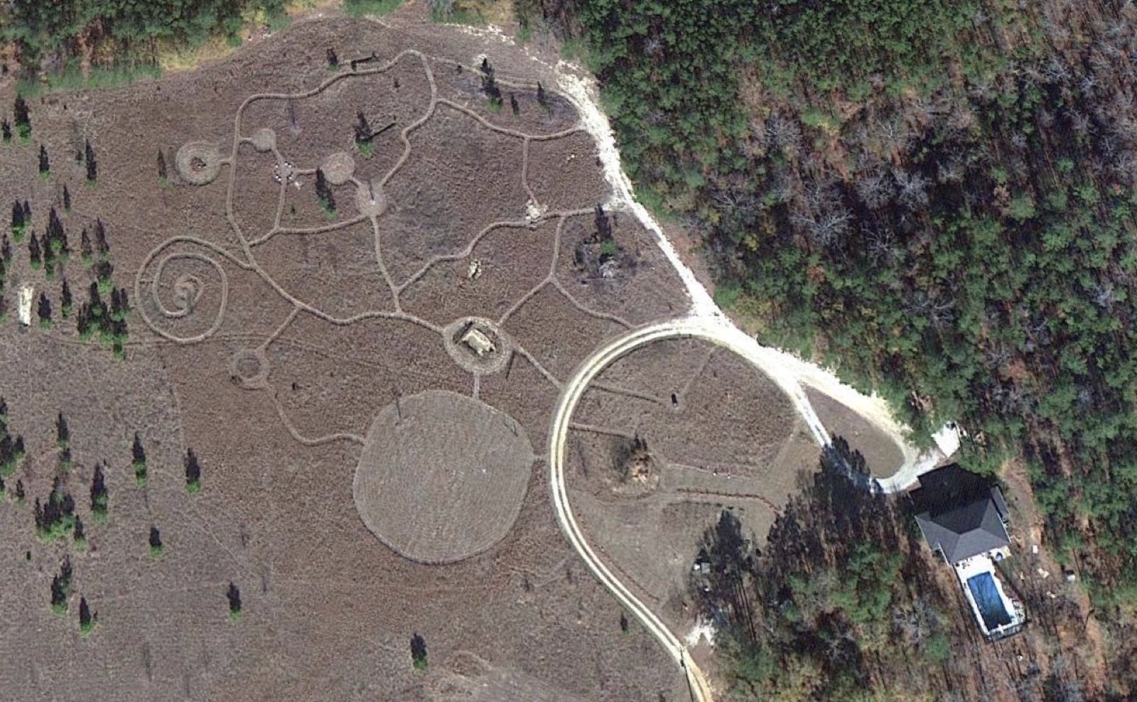 Aerial view of intricate crop circle formations with spiral and circular designs etched into a field