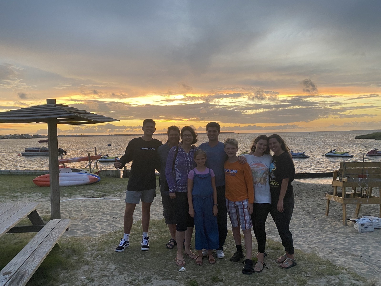 The whole family gathered on the beach at golden sunset