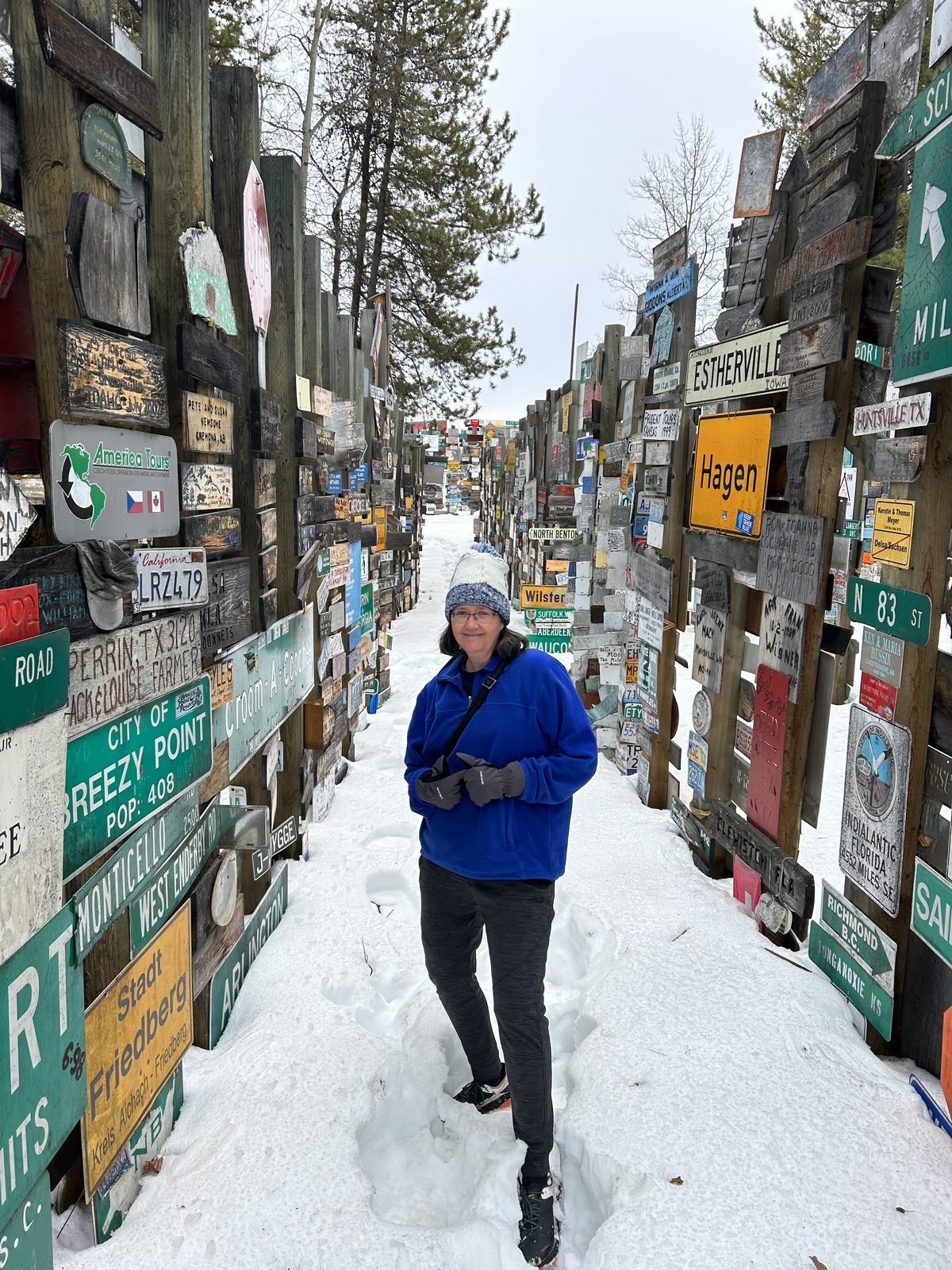 Allison at the Sign Post Forest trail landmark, hundreds of signs in snow
