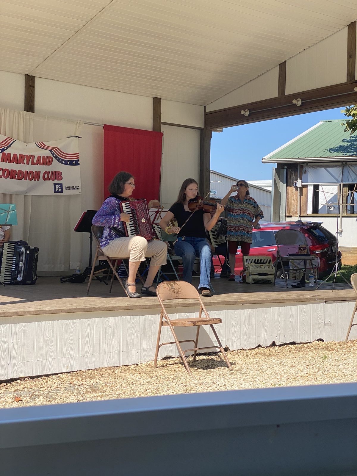 Allison playing accordion with the Maryland Accordion Club band outdoors